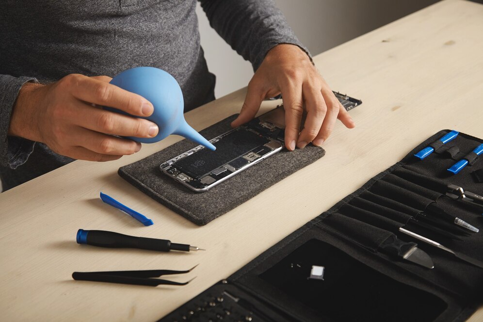 Technician inspecting a smartphone on a workbench